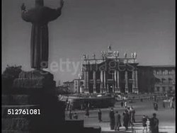 1950: ROME: VS EXT Basilica of St. John Lateran (Basilica di San Giovanni in Laterano). INT His Eminence Archbishop of New York Francis Cardinal Spellman carrying Christian Cross followed by Pilgrims w/ American flag walking in basilica. (too dark) Instructional Video