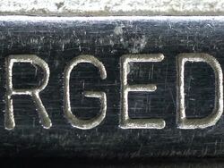 "FORGED IN U.S.A" shown in raised lettering on metal surface. Stock Footage