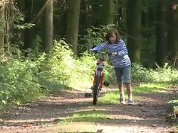 WS Girl with bicycle / Kastel-Staadt, Rhineland-Palatinate, Germany   Stock Footage