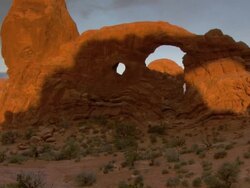 Turret Arch with dramatic morning sunshine and shadows across it's face - tilt up Stock Footage