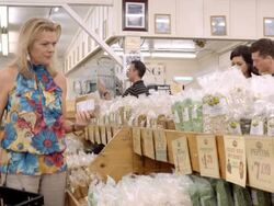 MS woman shopper in health food store browses shelves stacked with freshly bagged pumpkin seeds and pepitas / Cabazon, California, USA Stock Footage