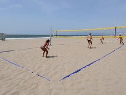 WS Establishing master shot of female beach volleyball players, showing the whole court,  serving and playing. Stock Footage