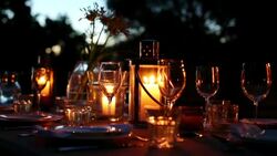 Table with luxury place settings in backyard at night Stock Footage