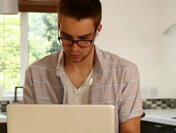 Young man, laptop, glasses, kitchen. Stock Footage