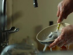 MS SLO MO Male hands washing cereal bowl with soap suds and dish  / Manchester, United Kingdombrush Stock Footage