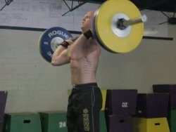 Medium close-up 3/4 profile. Dustin performs clean and jerk. Stock Footage