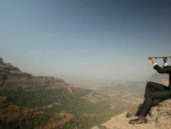 Businessman watching mountains through day telescope  Stock Footage