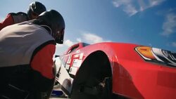 Stock car pit-crew changes race-car tire Stock Footage