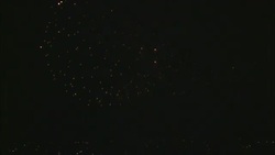 Orange fireworks explode in the night sky. Stock Footage