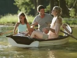 WS Pan of family rowing boat on lake Stock Footage