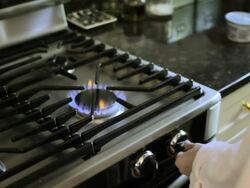 Woman lighting gas hob and putting kettle on Stock Footage