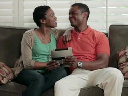 MS PAN TD Couple sitting on sofa and browsing on tablet computer / Portland, Oregon, United States Stock Footage