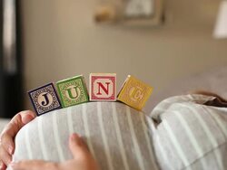 A pregnant women using blocks to spell the month of JUNE on her stomach. Stock Footage