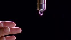 Closeup slow motion woman's fingers touch water running from a faucet creating backlight spray. Stock Footage