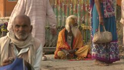 A holy man sits among pedestrians in India. Stock Footage