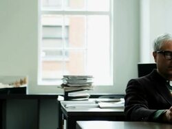 MS PAN businessman seated at workstation in office examining computer monitor and taking notes on notepad Stock Footage
