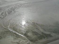 Aerial wide shot pan sun reflecting on Solway Firth mud flats/ Dumfries and Galloway, Scotland Stock Footage