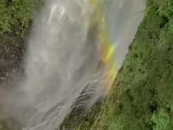 Aerial over waterfall with rainbow/ Fiordland National Park, New Zealand Stock Footage