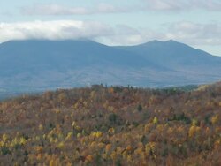 WS ARIEAL View of Green mountain in front of forest with clouds /Maine, United States Stock Footage