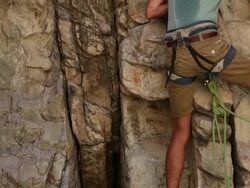 Tilt shot of a man starting his rock climb. Stock Footage