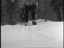 A line of skiers skis down a bumpy slope. News Clip