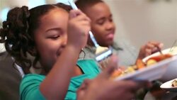 Father holds plate while daughter picks and serves herself a carrot Stock Footage