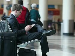 MS Well dressed young businessman using tablet device inside airport / Minneapolis, Minnesota, United States Stock Footage