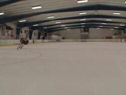 Long Shot hand-held - A hockey player skates toward the goal and shoots the puck, but misses. / North Carolina, USA Stock Footage
