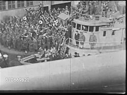 1918: TRAVELING BY SHIP: MS Steamer whistle. WS (POV Upper Deck) Ship leaving crowded dock, moving away from tug boat. President Woodrow Wilson (1856-1924) in coat, driving cap, binoculars around neck standing on deck of George Washington w/ officer. Instructional Video