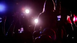 Crowd raising arms at concert with person sitting on shoulders Stock Footage
