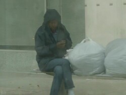 Homeless woman takes shelter in a bus stop Stock Footage