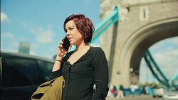 Woman calling at the phone by the Tower Bridge Stock Footage