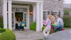Excited grandmother greets arriving family at the door (dolly-shot) Stock Footage