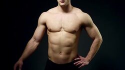 healthy athlete shows good muscle on black background Stock Footage