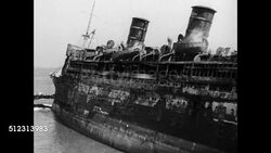 1934: SS MORRO CASTLE: HD: Silhouette of man standing on seaside rock cliff dressed in rain hat & coat. VS Listing & smoking ship at Asbury Park, people standing on nearby jetties, WS Burned lifeboats on side of cruise ship.  Note: poor contrast. Instructional Video