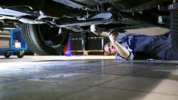 Car mechanic working under a vehicle. Stock Footage