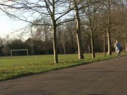 Man running through park, UK Stock Footage