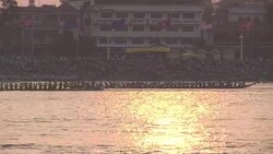 Longboats cruise past buildings on the Mekong River, Cambodia. Stock Footage