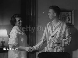 1953: NEWBORN: AFTER FEEDING: 'Grace & Walter Hobbs' standing by doorway looking across room, turning off light, leaving. Instructional Video