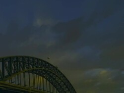 T/L WS ZO PAN Evening clouds as day turns to night and lights come on swimmers doing laps in North Sydney Olympic Pool in shadow of Sydney Harbour Bridge / Sydney, New South Wales, Australia Stock Footage