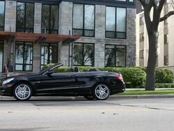 MS PAN Young man running out of modern apartment building and into  convertibel car before driving away on sunny day in urban area / Minneapolis, Minnesota, United States Stock Footage