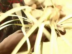 Woman with tattooed face braiding straw Stock Footage