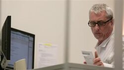 Older businessman calculates, dictates sum to client in small private corporate office Stock Footage