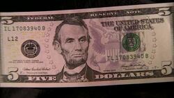Close up of five dollar note with face of Abraham Lincoln zoom in Stock Footage