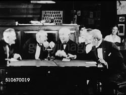1920s: SCIENCE: Scientist, inventor Thomas Alva Edison (1847-1931) sitting at table w/ other elder friends, colleagues, CU Thomas talking (No SOT), MS Thomas sitting (unidentified woman BG). Instructional Video
