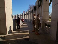 A static shot of two soldiers standing in the shadows of the World War II Memorial. Stock Footage