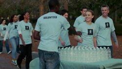 Volunteers pass water station on charity walk Stock Footage