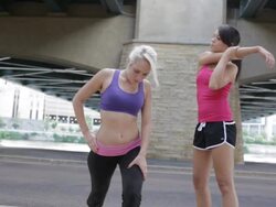 MS Two young girls stretching their legs in preparation for run together / Minneapolis, Minnesota, United States Stock Footage