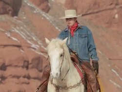 PAN Cowboy and cowgirl talking while riding horses along hill top / Shell, Wyoming, United States Stock Footage