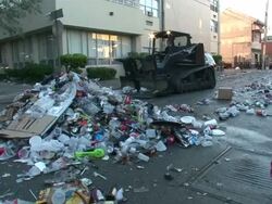 Wide Shot High Angle - Garbage truck moving trash down a street / New Orleans Louisiana Stock Footage